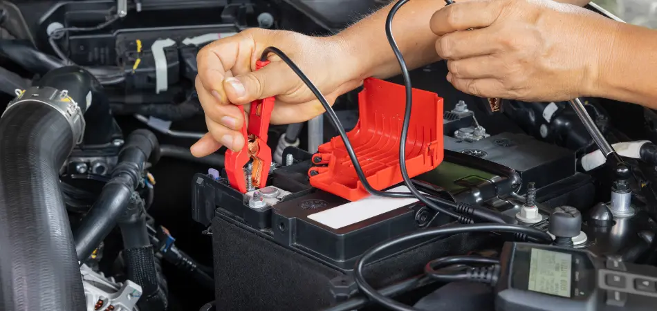 A man connects jumper cables to an AGM battery