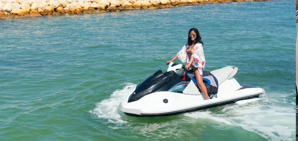 A woman drives her jet ski to shore