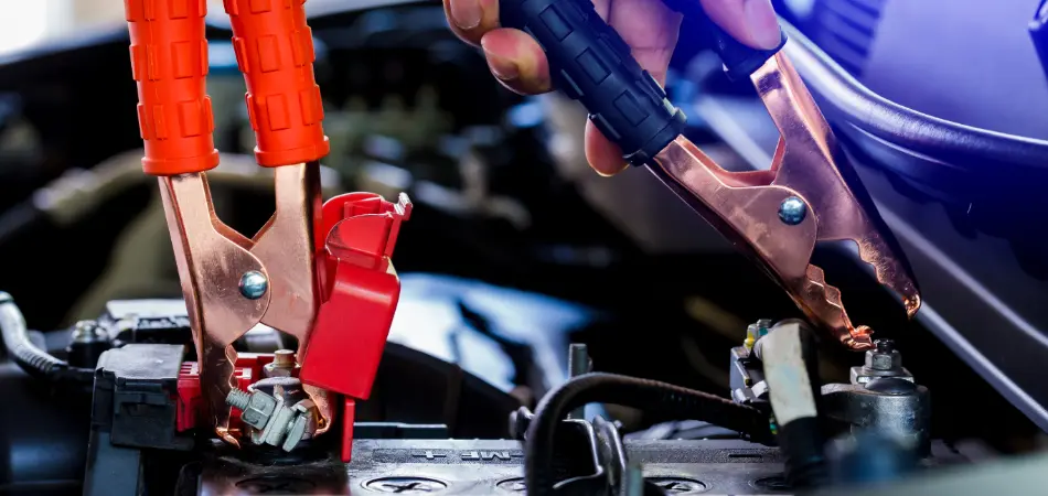 Close-up of jumper cables connected to a car battery