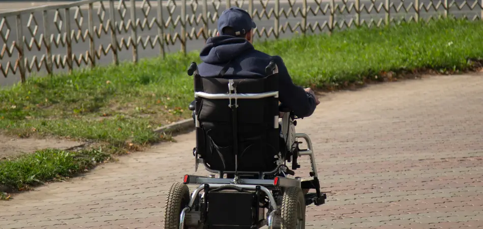A man in a motorized wheelchair enjoys the park