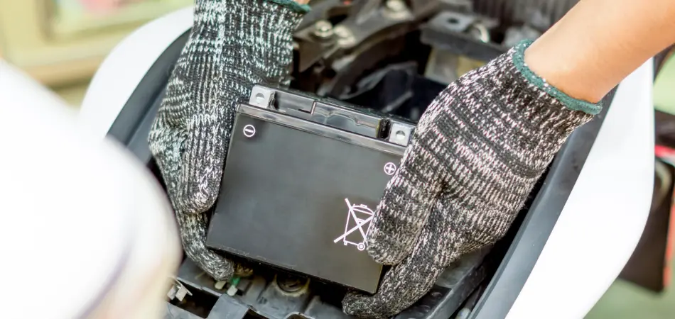 A man installs a motorcycle battery