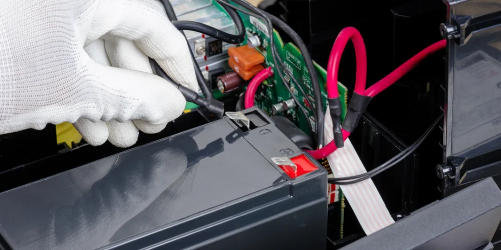 A mechanic attaches a positive battery terminal