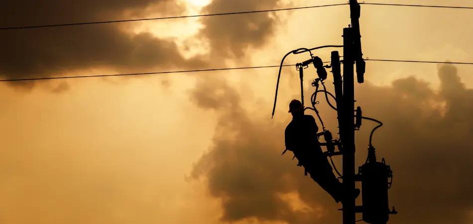 A worker repairs power lines